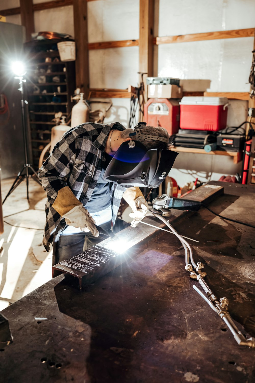a man welding a piece of metal in a garage