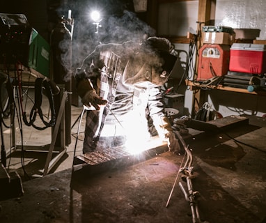 a man working on a piece of metal in a garage