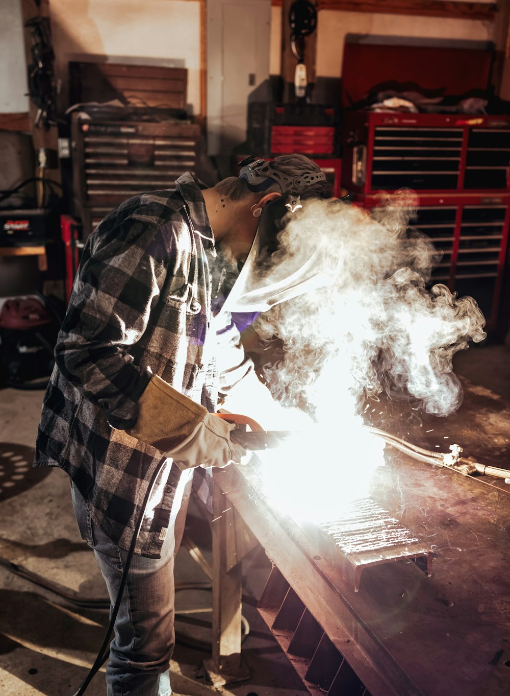 Un hombre trabajando en una pieza de metal en un garaje