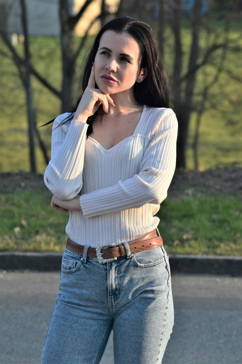 Eine Frau in Jeans und Pullover posiert für ein Foto