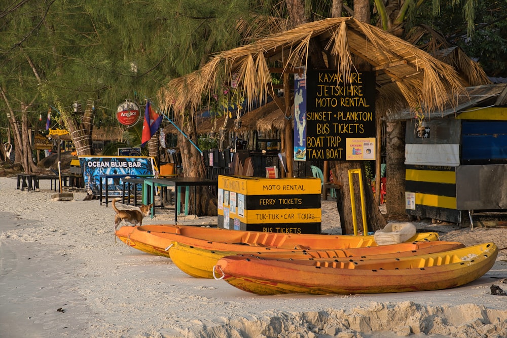 a row of boats sitting on top of a sandy beach