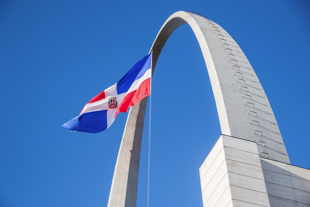 a flag flying in front of the st louis arch