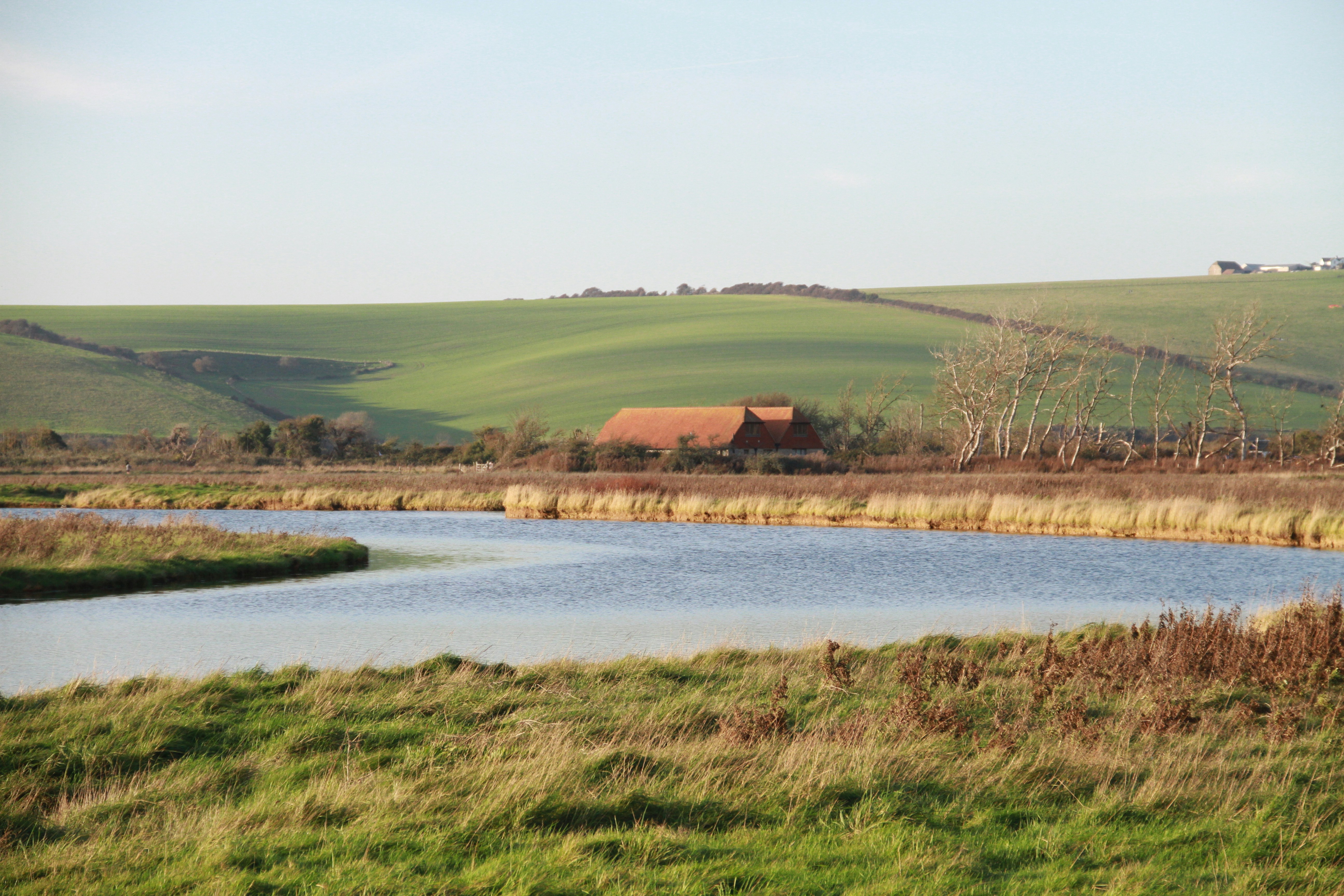 a large body of water surrounded by lush green hills