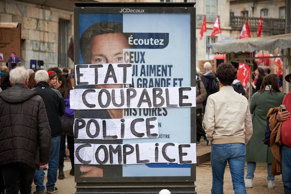 a group of people standing around a poster