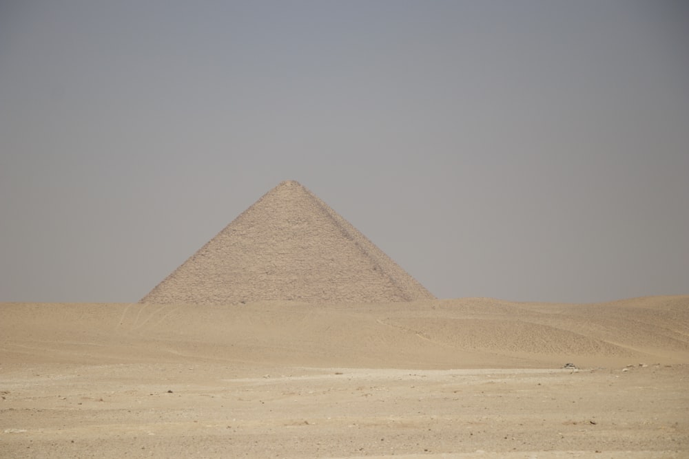 uma pirâmide muito alta no meio de um deserto