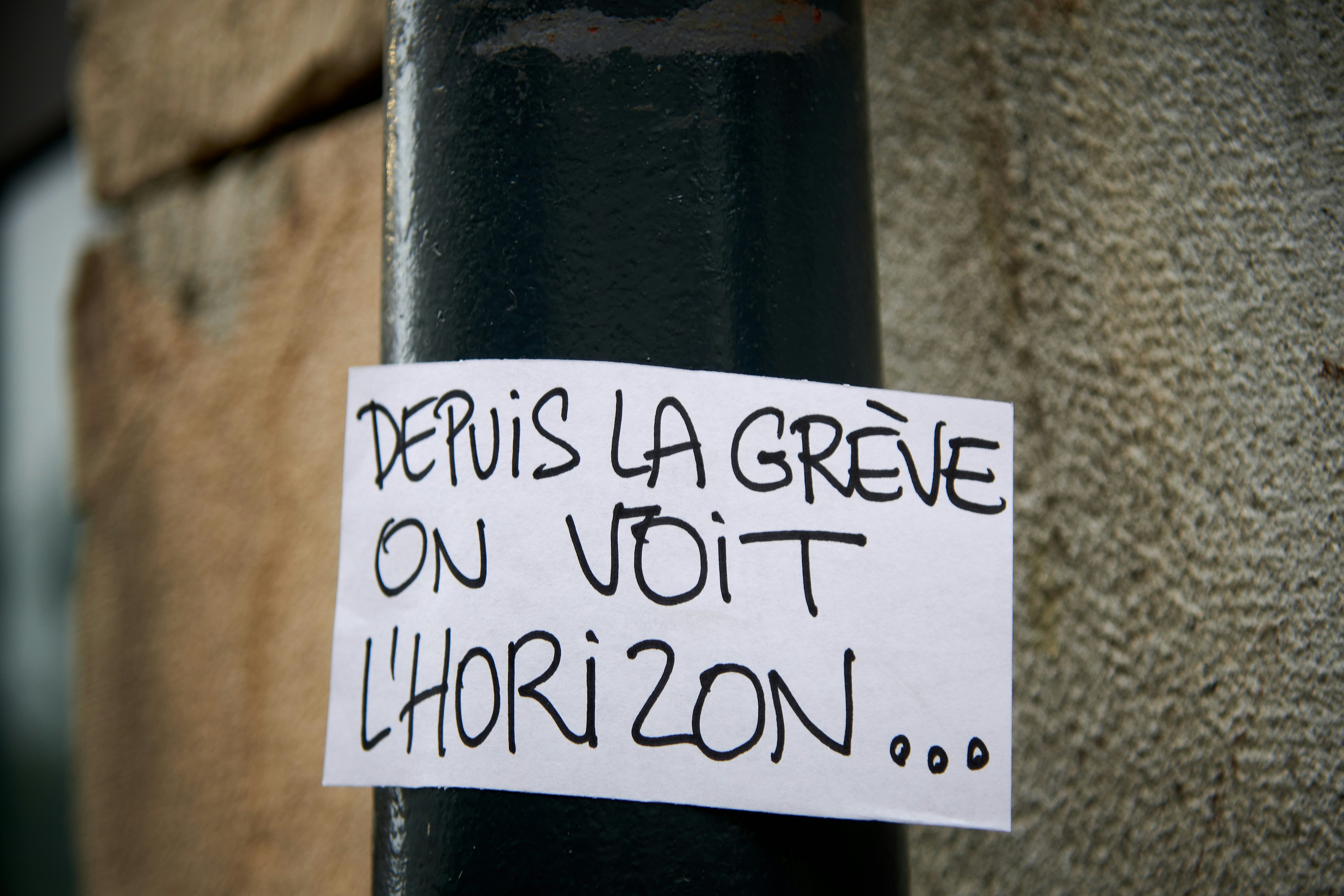 a piece of paper taped to a black pole