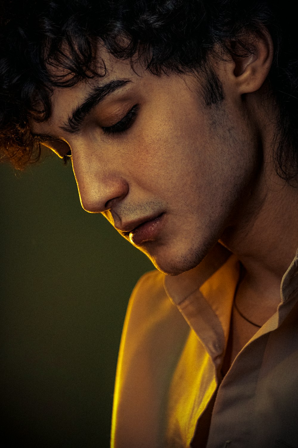 a man with curly hair is looking down