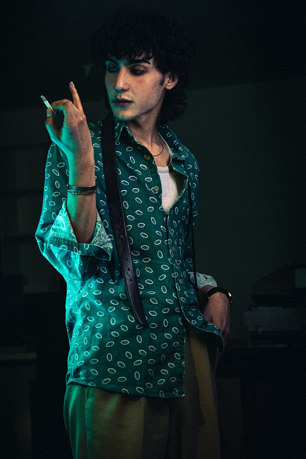 a man smoking a cigarette in a dark room