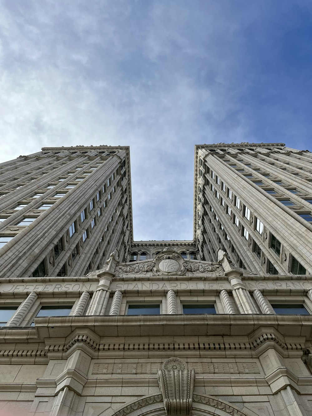 looking up at two tall buildings in a city