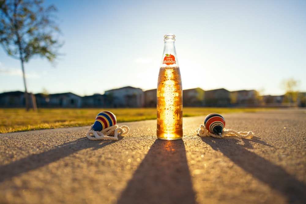 a bottle of beer sitting on the side of a road