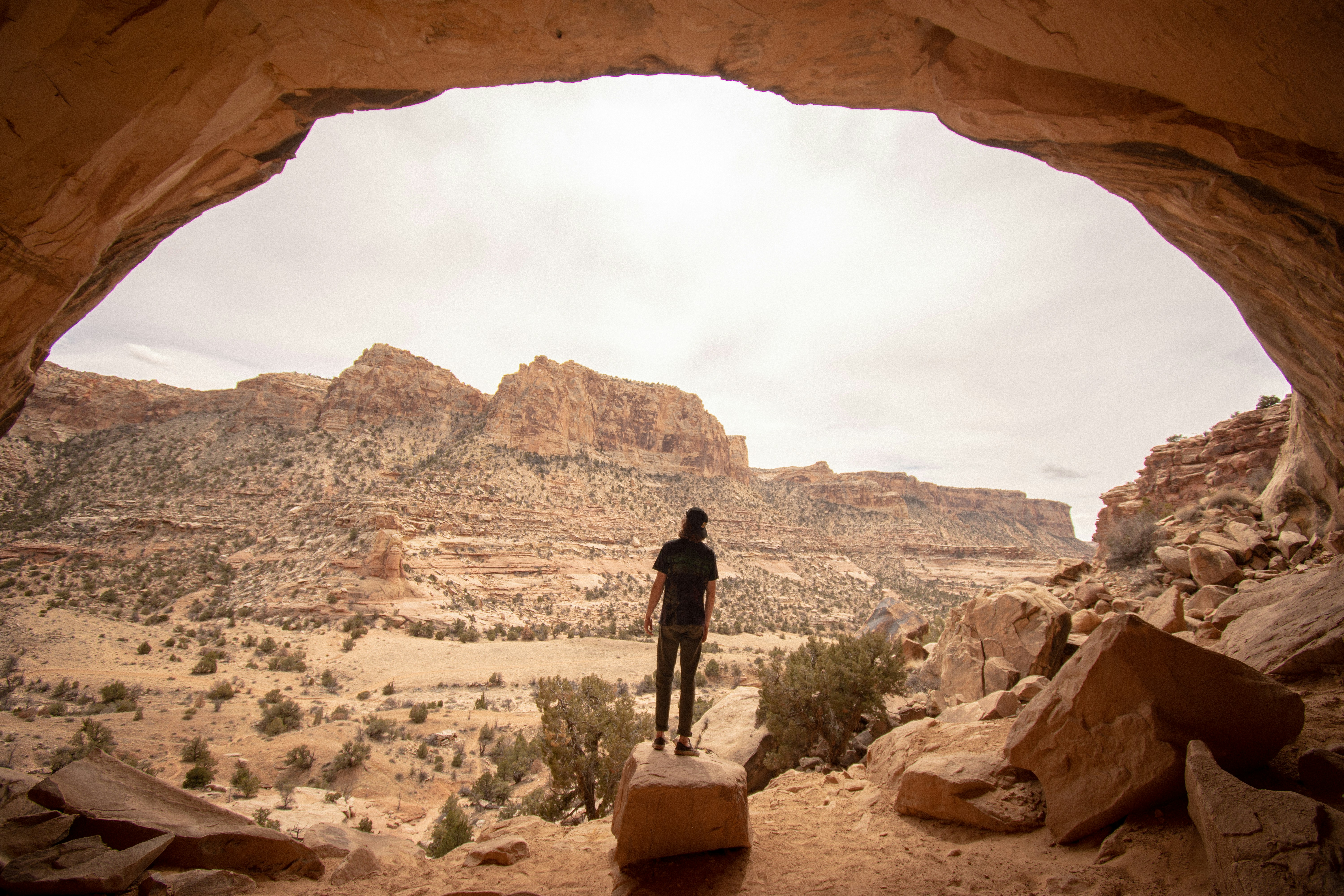 a person standing at the entrance to a cave