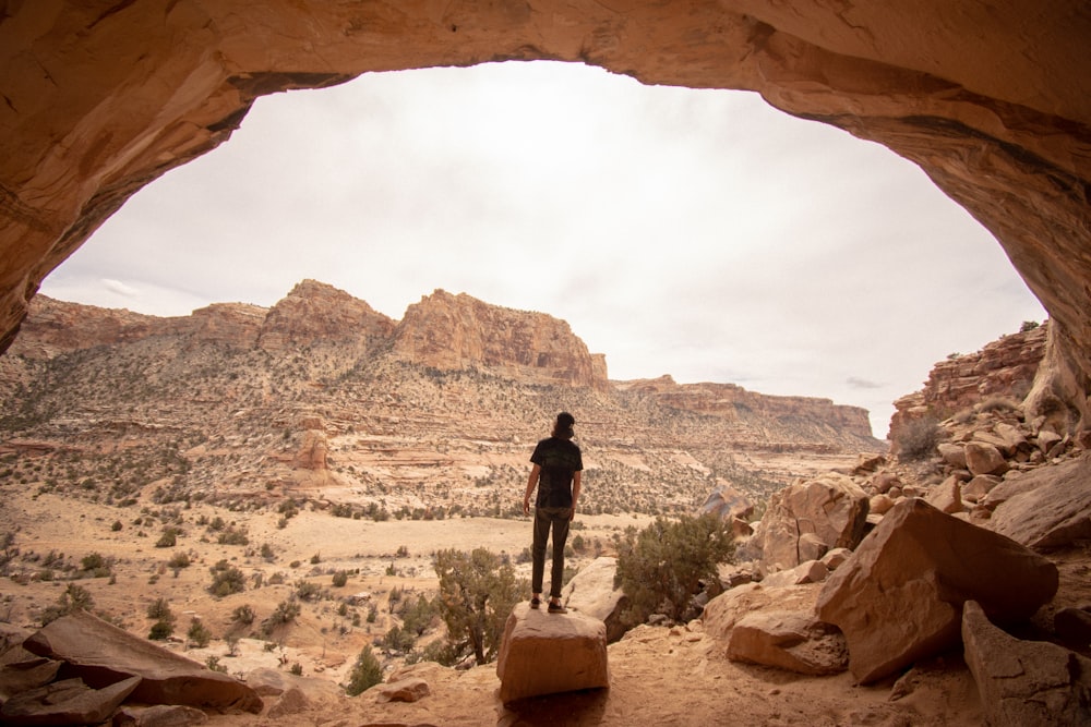 a person standing at the entrance to a cave