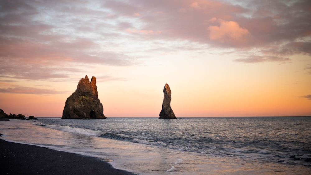 a couple of large rocks sticking out of the ocean