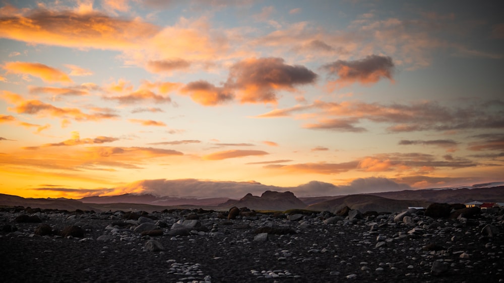 a man riding a horse across a rocky field