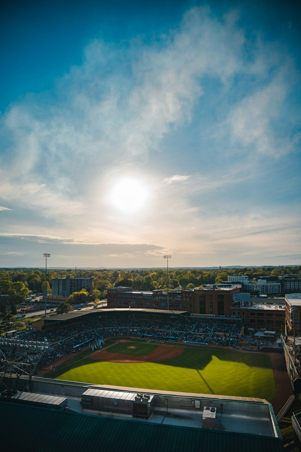 a baseball field with the sun in the background