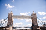 The iconic London Bridge framed by a clear blue sky, bustling with tourists.