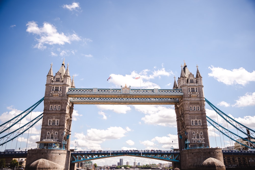 a tall bridge spanning over a river under a blue sky