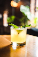 An inviting mint mojito with crushed ice, fresh mint leaves, and a golden straw, glowing under soft lighting.