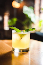 A stylish black-background photo of a mojito cocktail with fresh mint and lime on a terrace table at dusk
