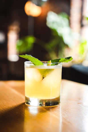 A stylish black-background photo of a mojito cocktail with fresh mint and lime on a terrace table at dusk