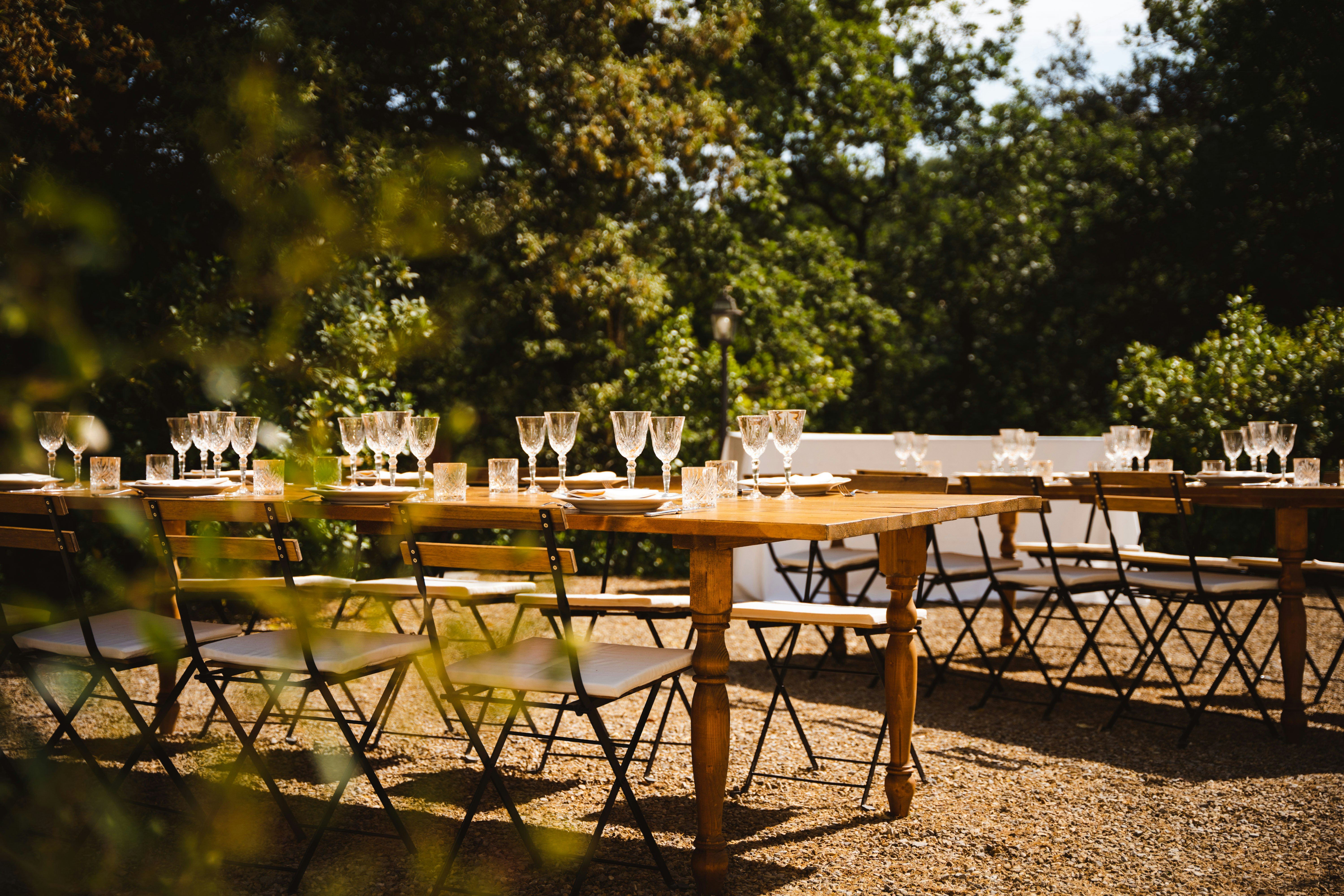 a long table set up with empty wine glasses, Italian evening wedding