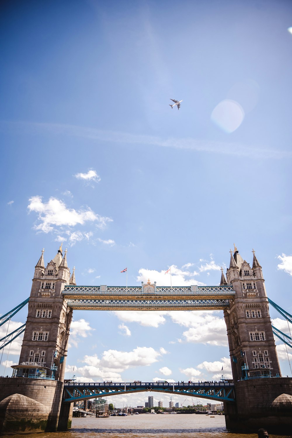 a plane flying over a bridge on a sunny day