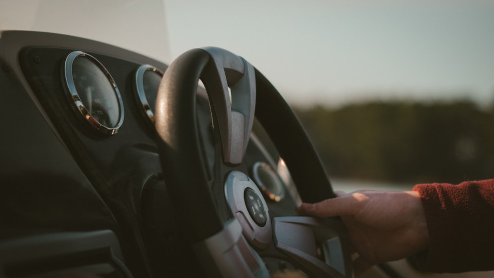 a person holding the steering wheel of a vehicle