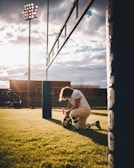 Dramatic close-up of a football player mid-air, muscles tense, under stadium lights.