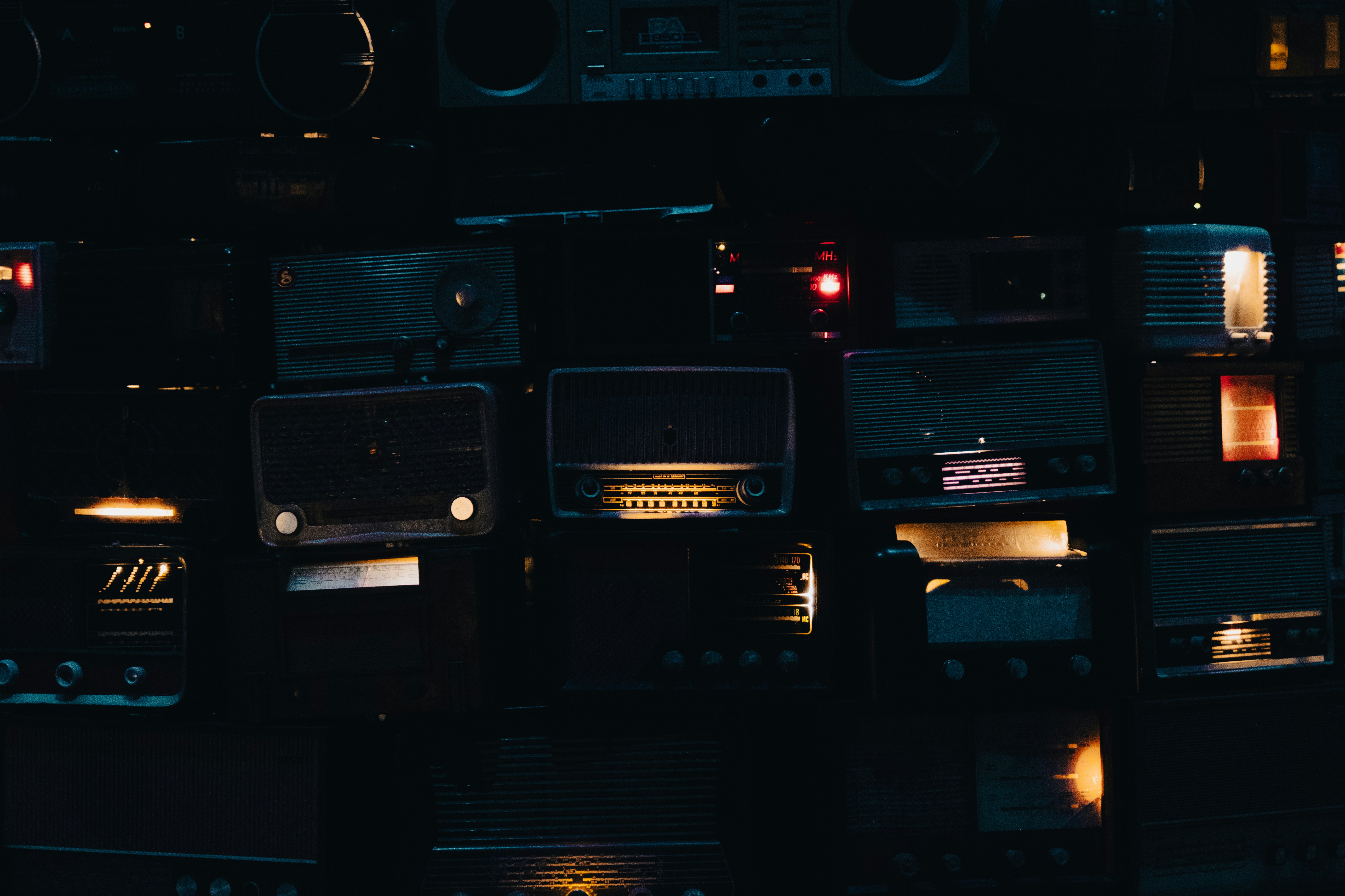 a wall of old radio's in a dark room