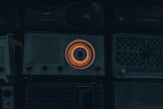 A cozy shelf filled with carefully restored vintage transistor and tube radios glowing softly in warm light.