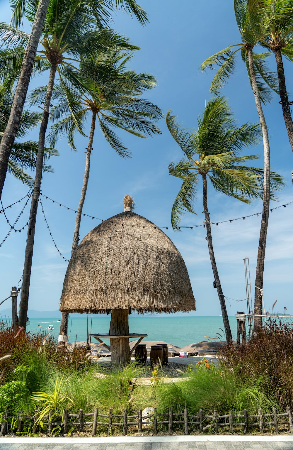 a hut with a thatched roof surrounded by palm trees