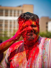 A colorful splash of powdered Holi colors blending softly over a blurred gradient background.