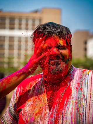 A colorful splash of powdered Holi colors blending softly over a blurred gradient background.