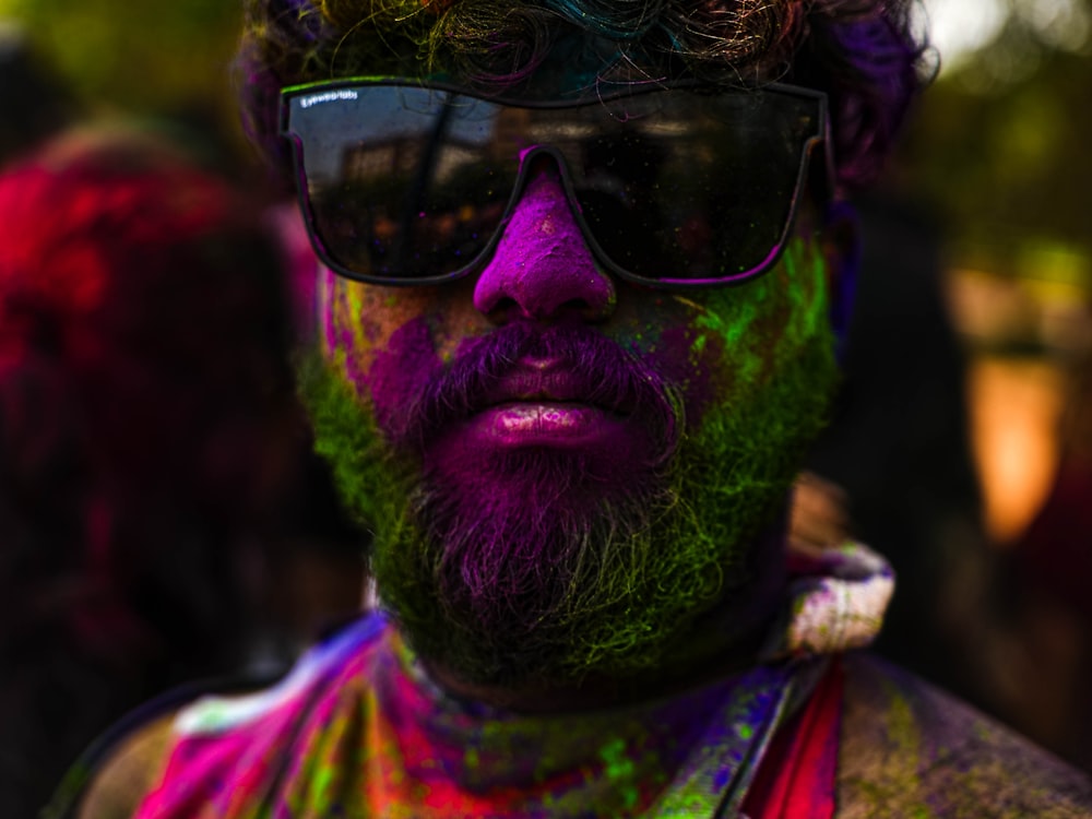 a man with a beard and glasses covered in paint
