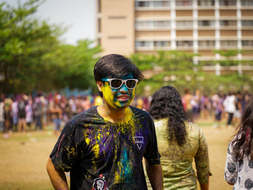 a man with paint on his face standing in front of a crowd of people