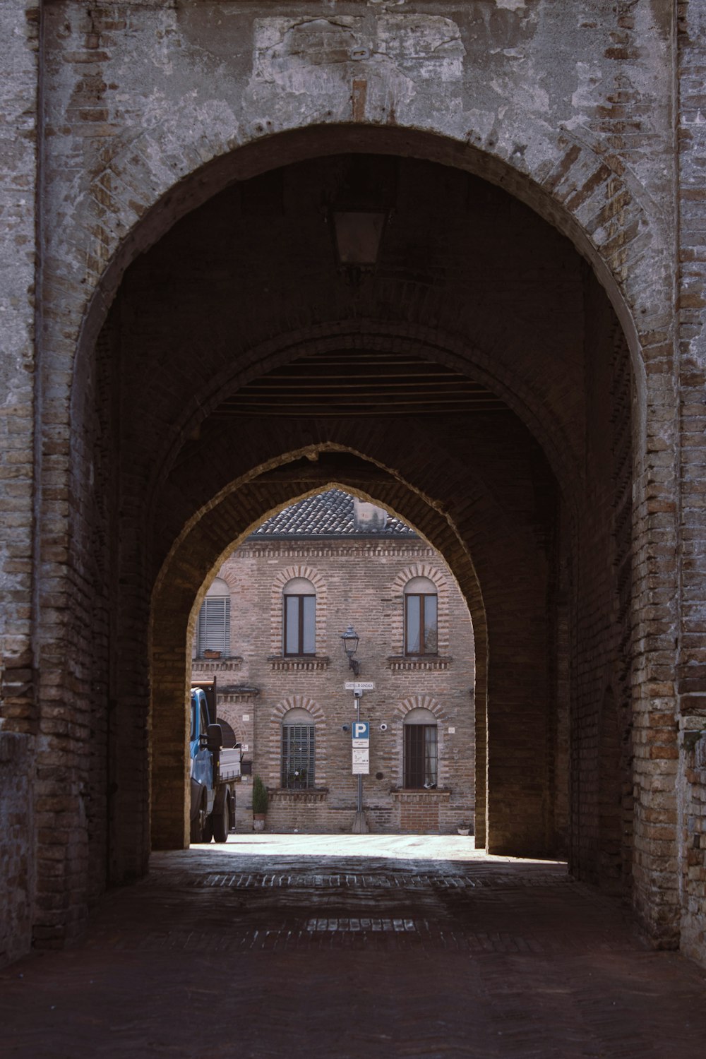 an archway leading to a building with a clock on it