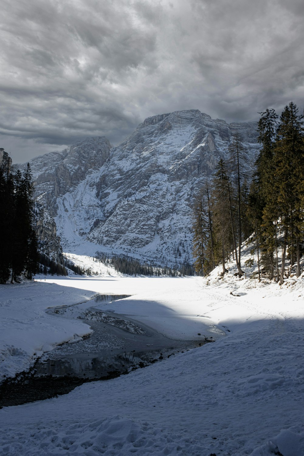 a snow covered mountain with a stream running through it