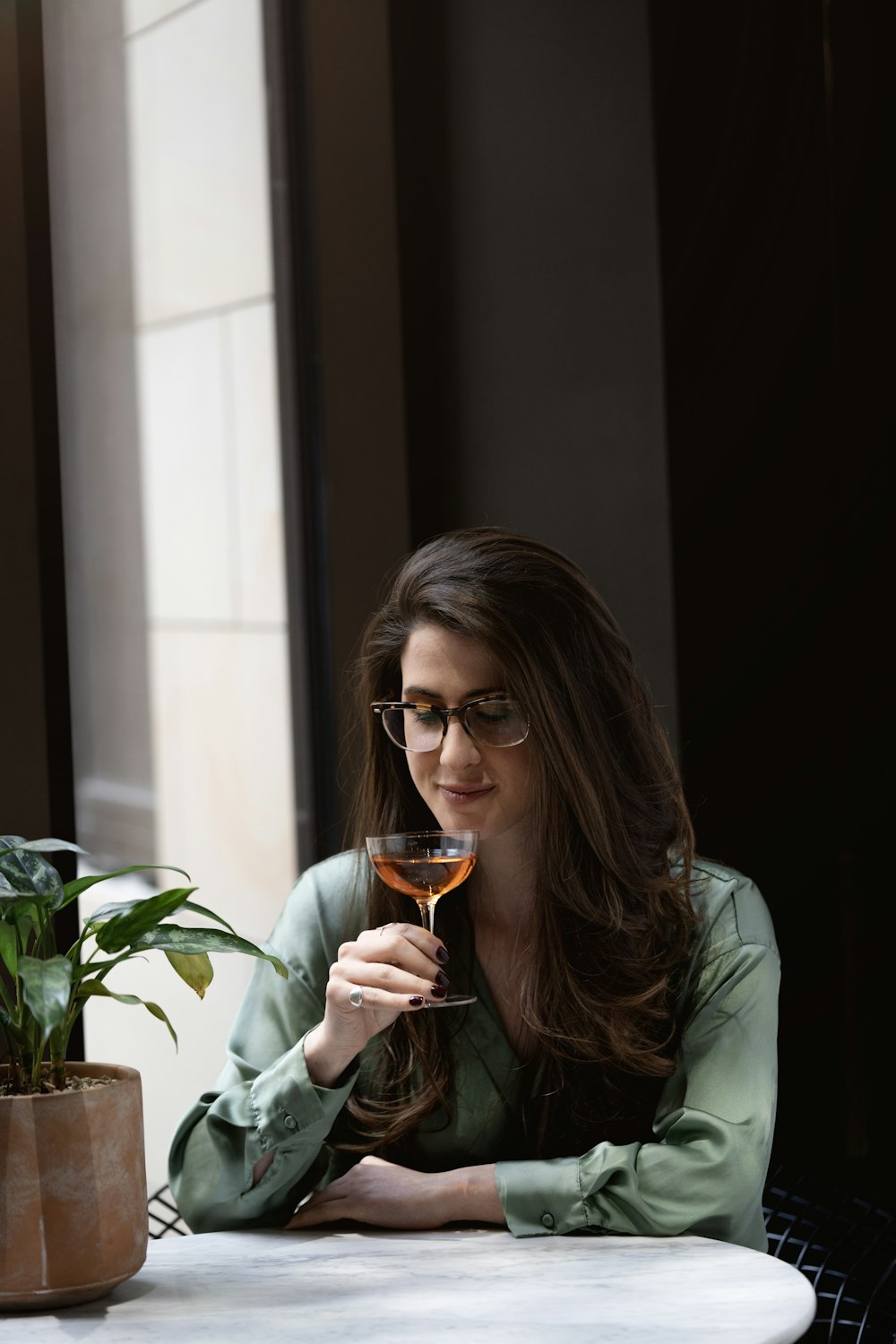 a woman sitting at a table with a glass of wine