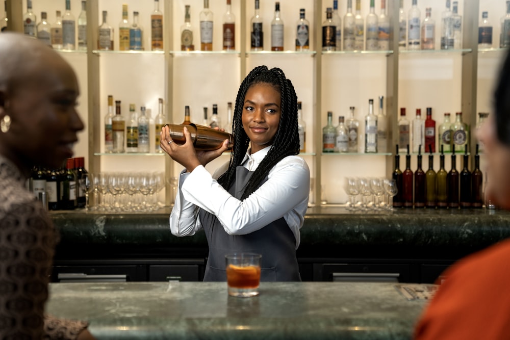 a woman standing at a bar pouring a drink