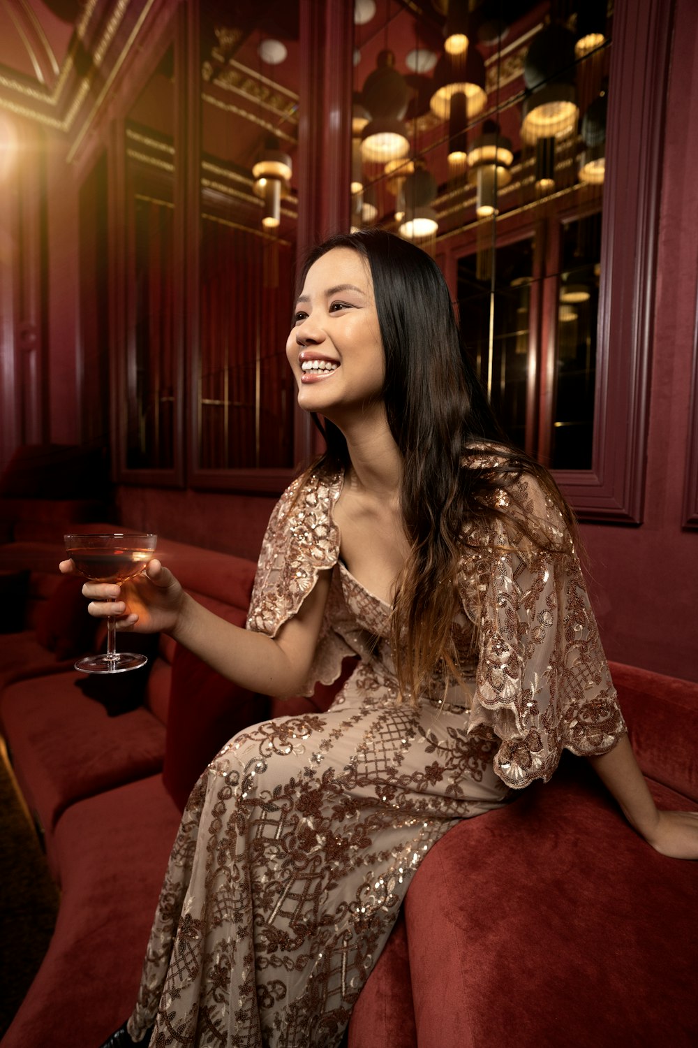 a woman sitting on a couch holding a glass of wine