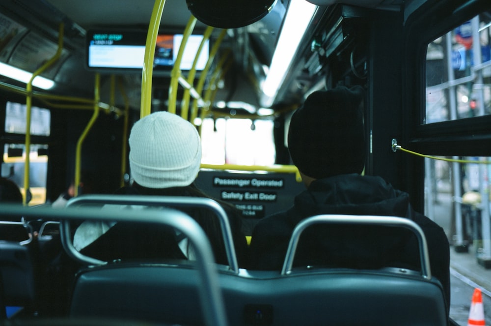 a person wearing a white hat is sitting on a bus