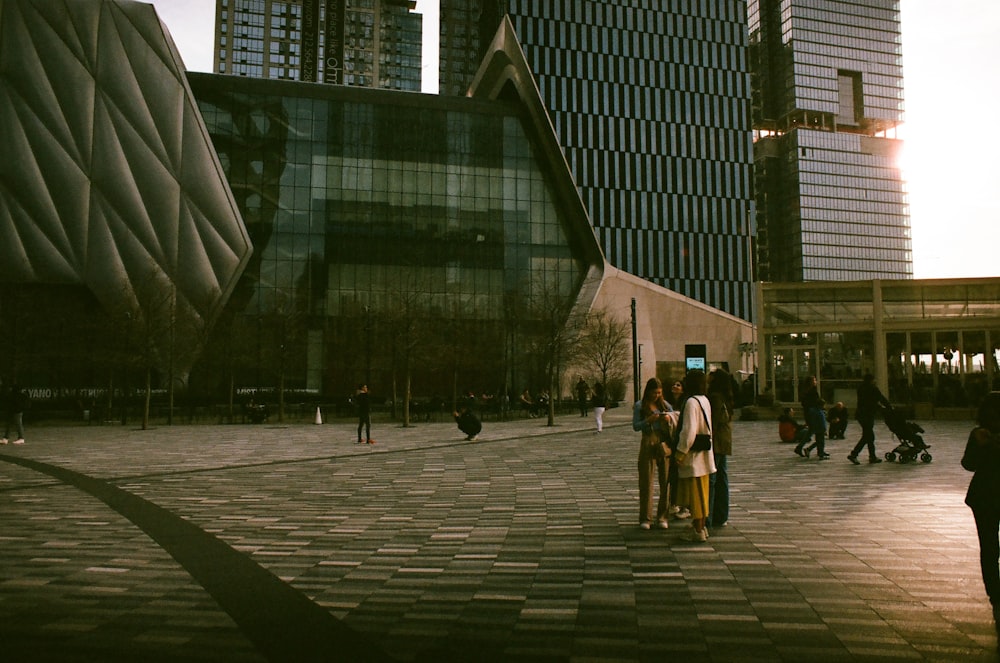 a group of people standing in a courtyard next to tall buildings