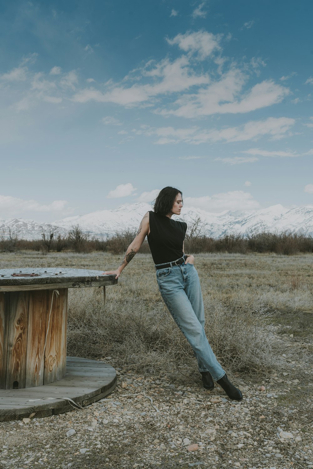 a woman leaning on a table in a field