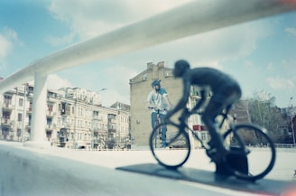a man riding a bike down a street next to tall buildings