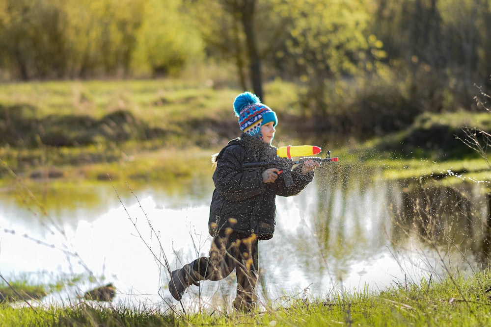 Un niño pequeño está jugando con un juguete en la hierba