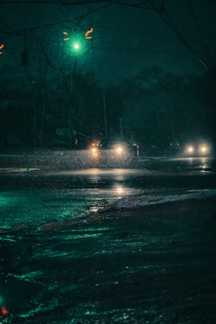 A cinematic scene with dim city lights reflecting on rain-soaked streets at night
