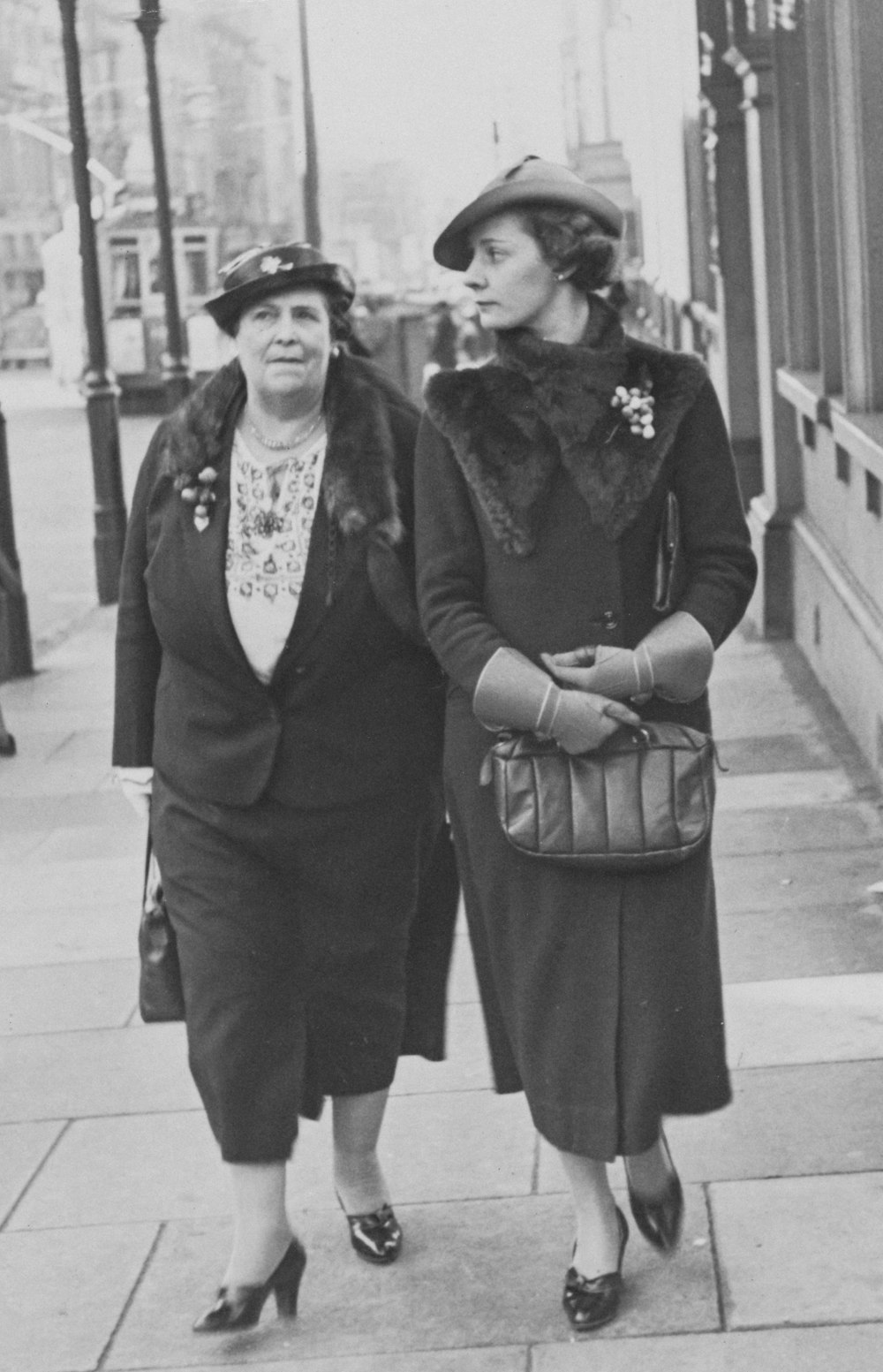 two women walking down a sidewalk next to each other