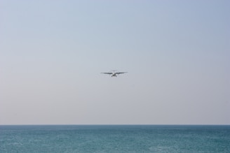 A serene ultralight aircraft soaring above a calm blue lake at sunset.