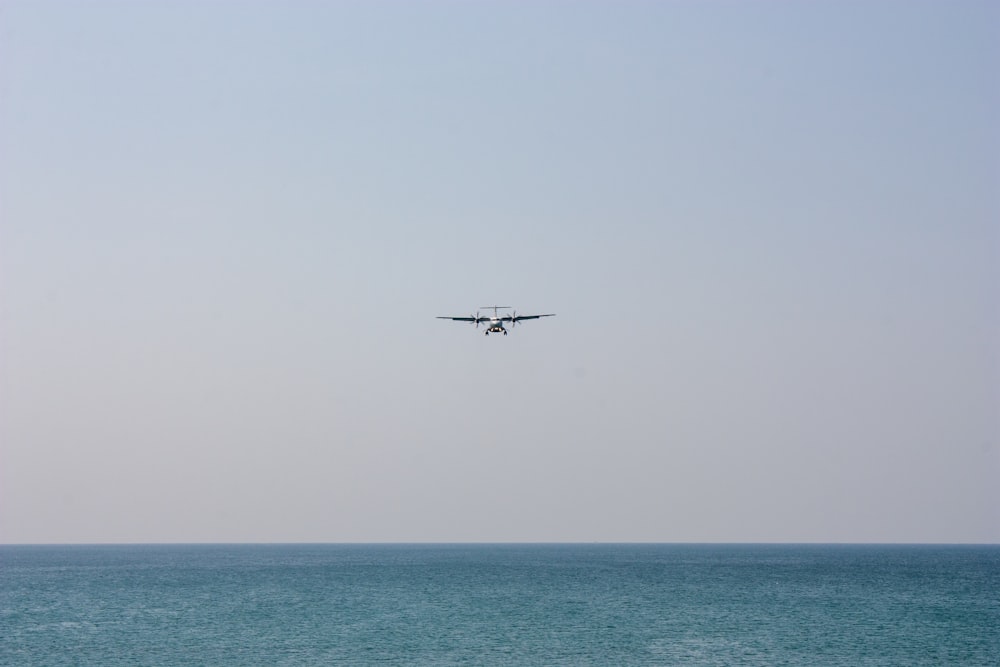 Ein Flugzeug, das an einem klaren Tag über den Ozean fliegt