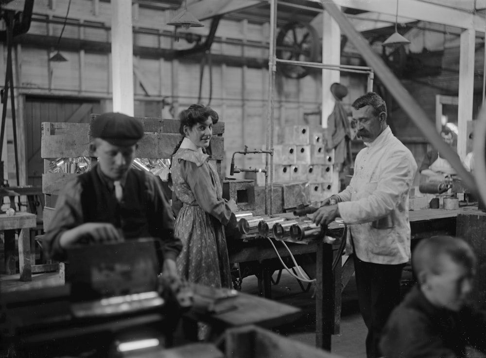 a black and white photo of people working in a factory